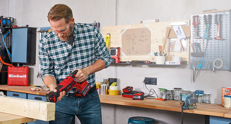 a man works with a cordless Einhell Saw in a workshop