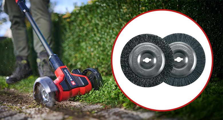 A man removes weeds between paving stones with an Einhell grout cleaner; next to him are two replacement brushes made of steel and nylon.