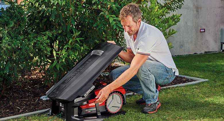 man fixes roof for robot lawn mower