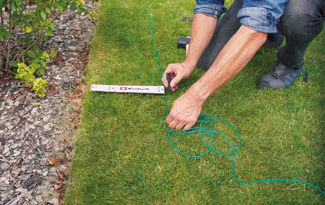 someone installs the perimeter wire for a Einhell robot mower