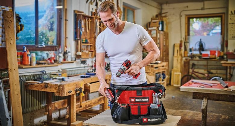 A man uses a Einhell bag in a workshop.