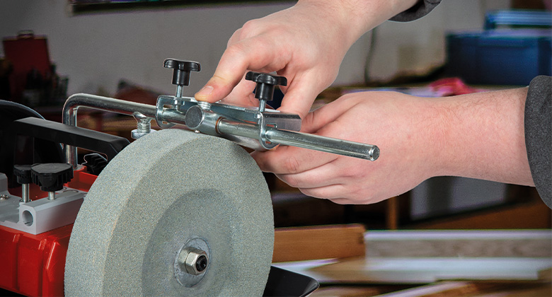 Hands adjusting a fixture on an Einhell wet grinder.