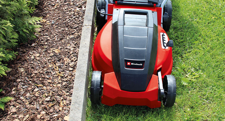 Einhell electric lawnmower mowing close to an edge