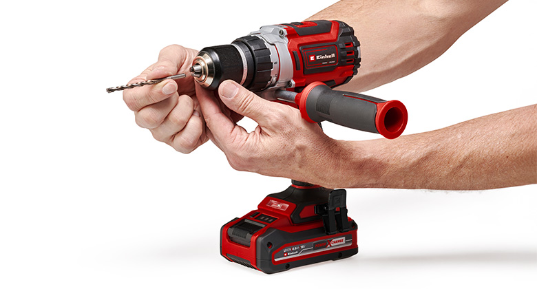 A person secures a drill bit in a cordless drill.
