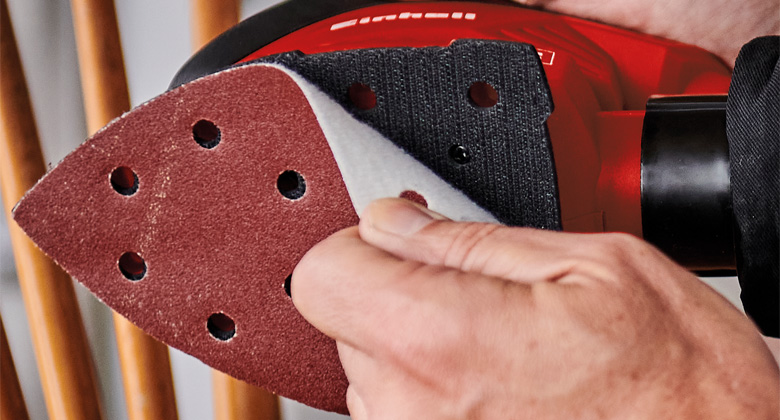 someone changing sanding paper on grinder