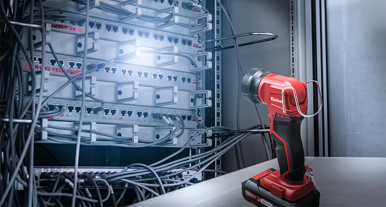An Einhell battery lamp sheds light on a server rack.