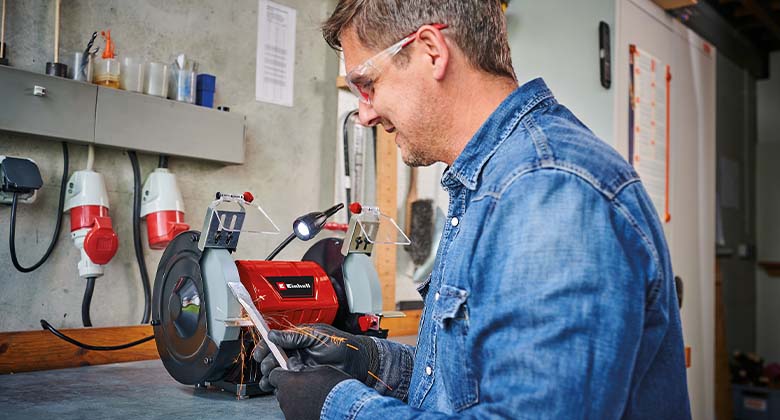 man using a bench grinder