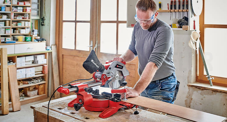 man using a pull-cut mitre saw