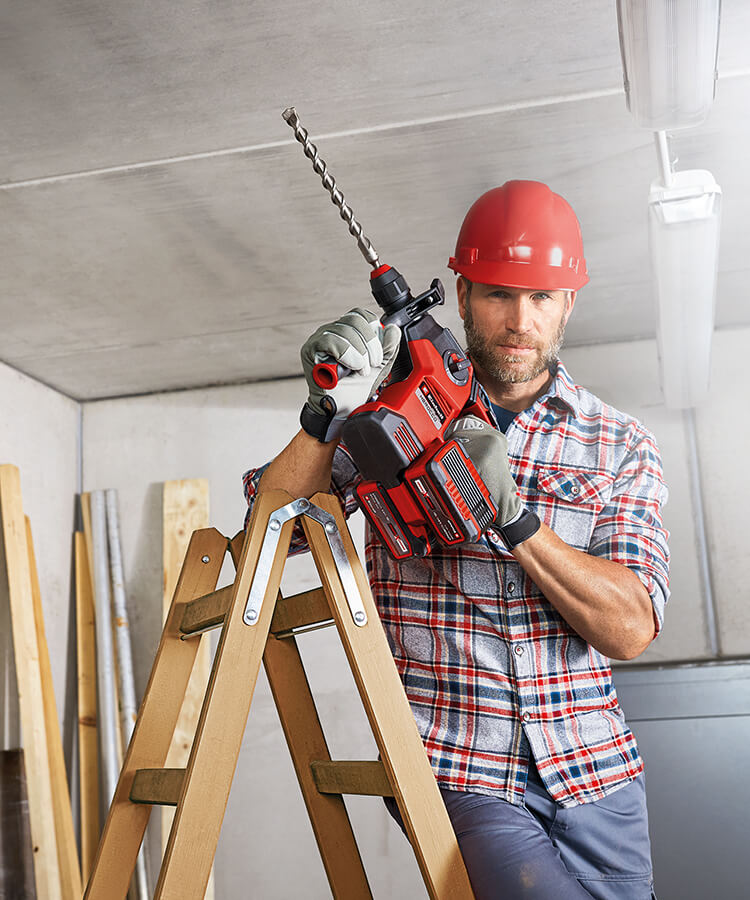 man working with a cordless rotary hammer